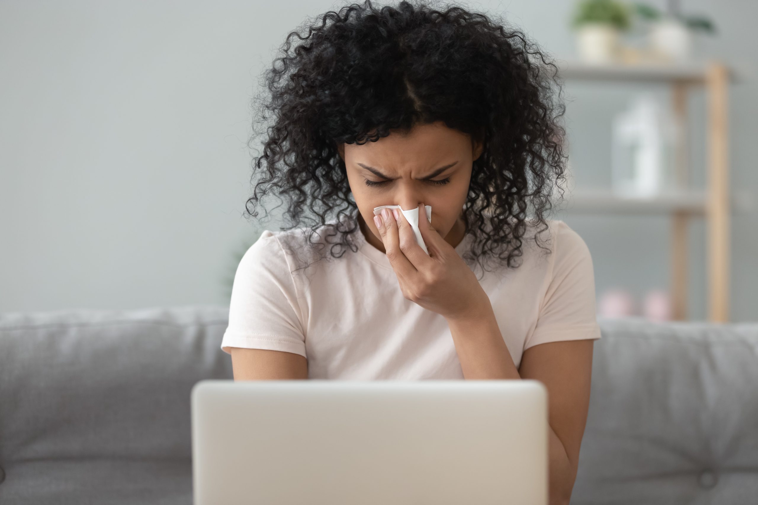 Woman on laptop with allergies air filtration and indoor air quality
