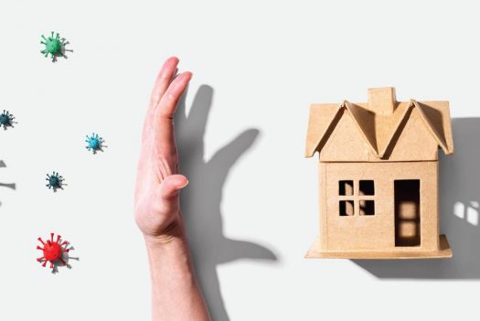 Image of cardboard home with hand protecting it from viruses entering. Indoor air quality